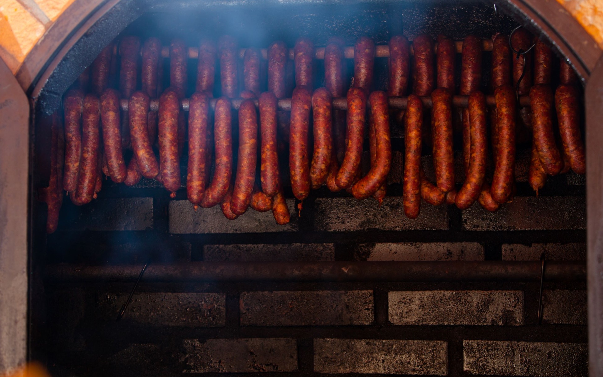 Carne a fumar num defumador de tijolo